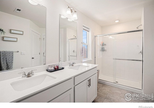 7415 E 158th Pl, Thornton, CO 80602 - bathroom featuring a shower stall, double vanity, and tile patterned flooring