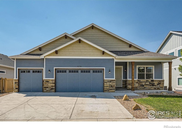 5279 Long Dr, Timnath, CO 80547 - craftsman-style home featuring an attached garage, stone siding, driveway, and covered porch