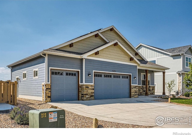 5279 Long Dr, Timnath, CO 80547 - craftsman house featuring an attached garage, driveway, and stone siding