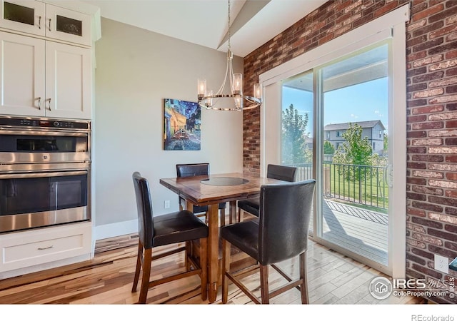 5279 Long Dr, Timnath, CO 80547 - dining room featuring light wood finished floors, a chandelier, and brick wall