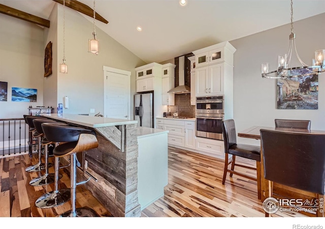 5279 Long Dr, Timnath, CO 80547 - kitchen with wall chimney exhaust hood, stainless steel appliances, light wood finished floors, white cabinets, and backsplash