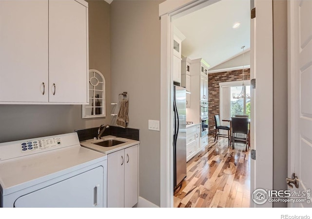 5279 Long Dr, Timnath, CO 80547 - washroom with washer / dryer, cabinet space, and light wood-style floors