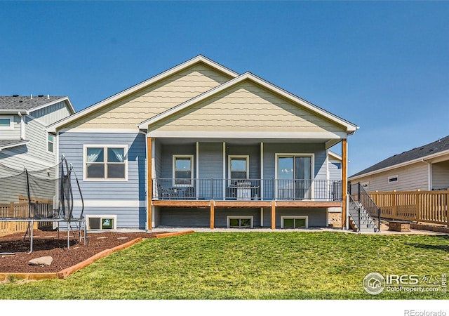 5279 Long Dr, Timnath, CO 80547 - view of front of house with a trampoline, a front lawn, and stairway