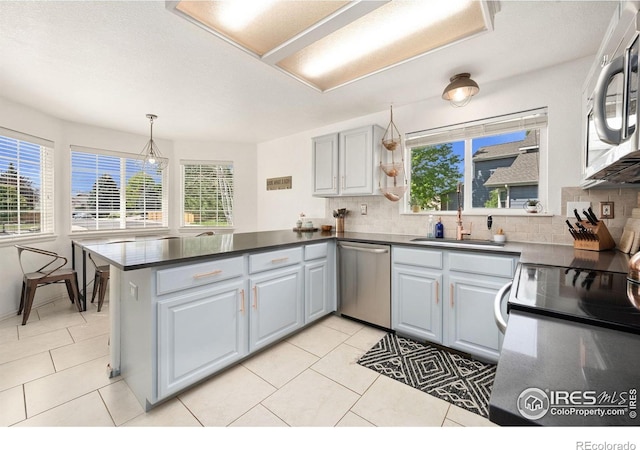 6836 Timpas Dr, Fort Collins, CO 80525 - kitchen featuring stainless steel appliances, a peninsula, backsplash, and dark countertops
