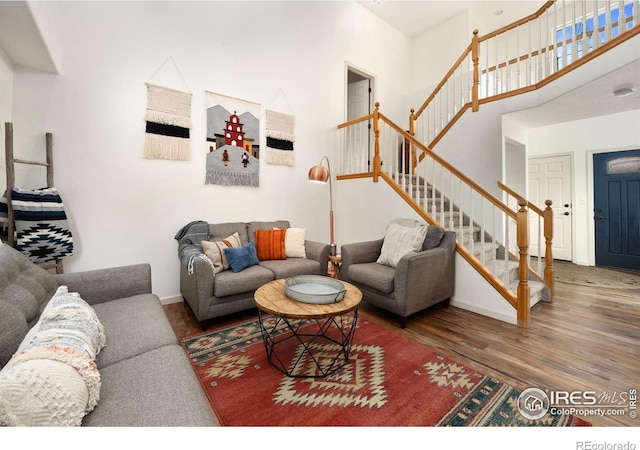6836 Timpas Dr, Fort Collins, CO 80525 - living room featuring stairs, wood finished floors, and a towering ceiling