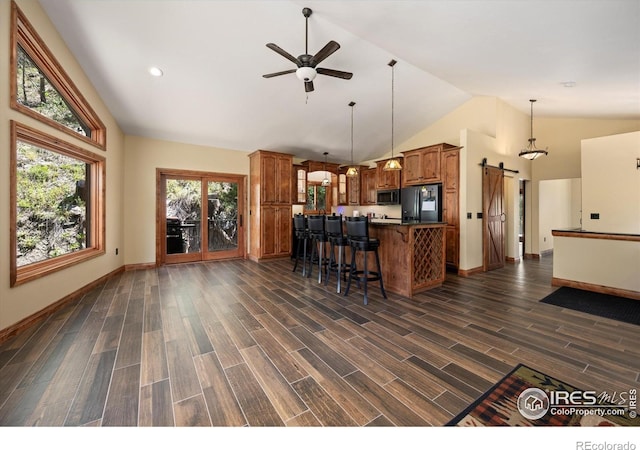200 Falls Creek Dr, Bellvue, CO 80512 - kitchen with a barn door, black appliances, brown cabinets, high vaulted ceiling, and a ceiling fan