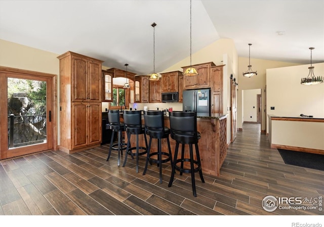 200 Falls Creek Dr, Bellvue, CO 80512 - kitchen with stainless steel refrigerator with ice dispenser, black microwave, dark wood finished floors, brown cabinets, and lofted ceiling