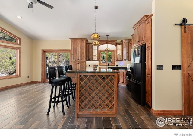 200 Falls Creek Dr, Bellvue, CO 80512 - kitchen with black fridge, dark countertops, dark wood-style flooring, a center island, and recessed lighting