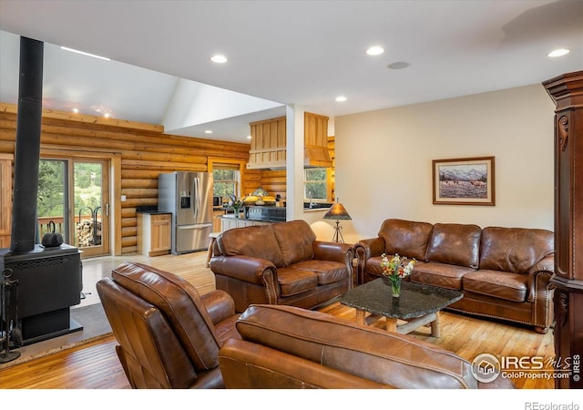 280 Hummer Dr, Nederland, CO 80466 - living area featuring a wood stove, log walls, light wood finished floors, healthy amount of natural light, and recessed lighting