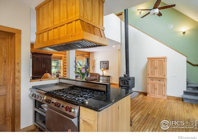 280 Hummer Dr, Nederland, CO 80466 - kitchen featuring stainless steel gas stove, light wood-style flooring, a ceiling fan, dark stone counters, and custom range hood