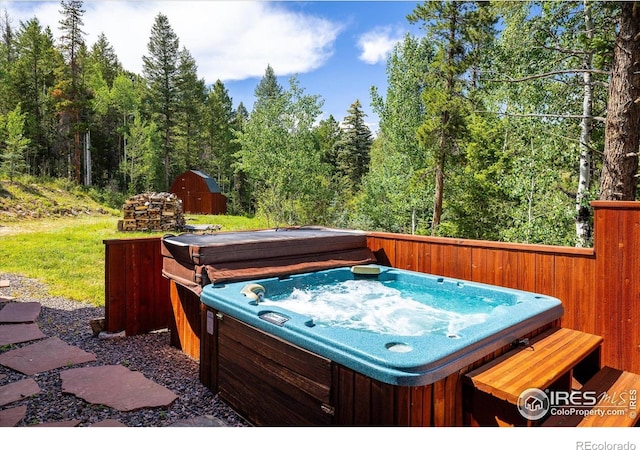 280 Hummer Dr, Nederland, CO 80466 - wooden deck featuring a hot tub, a shed, and a wooded view