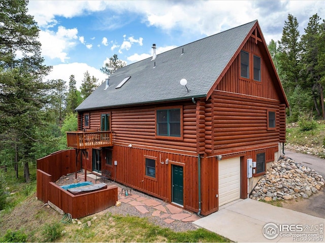 280 Hummer Dr, Nederland, CO 80466 - rear view of property with an attached garage, driveway, log exterior, a shingled roof, and board and batten siding