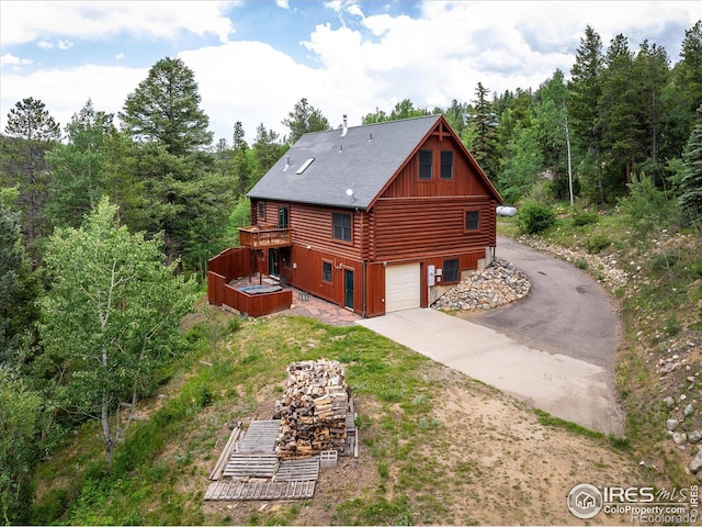 280 Hummer Dr, Nederland, CO 80466 - view of side of property featuring driveway, log exterior, a garage, and a deck
