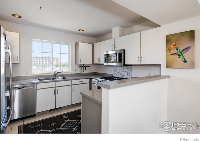 3970 Colorado Ave Unit G, Boulder, CO 80303 - kitchen featuring stainless steel appliances, a peninsula, white cabinets, light tile patterned flooring, and decorative backsplash