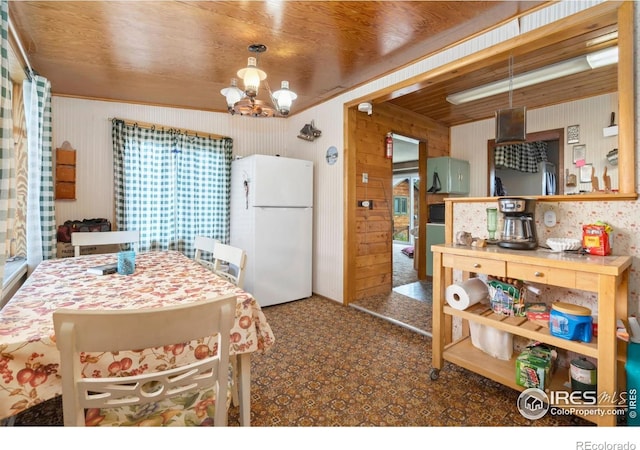 983 Ramona Dr, Red Feather Lakes, CO 80545 - carpeted dining area with a chandelier and wood walls