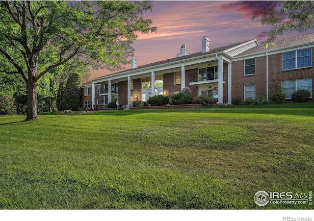 39 Ward Dr Unit 202, Greeley, CO 80634 - view of front of house featuring a chimney, a front lawn, and brick siding