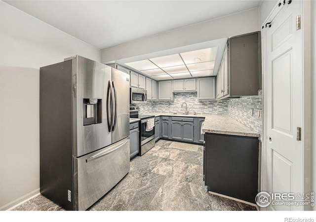 39 Ward Dr Unit 202, Greeley, CO 80634 - kitchen with appliances with stainless steel finishes, gray cabinets, light countertops, and backsplash