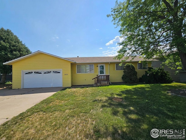 1402 Fillmore St, Sterling, CO 80751 - ranch-style house featuring driveway, an attached garage, and a front lawn