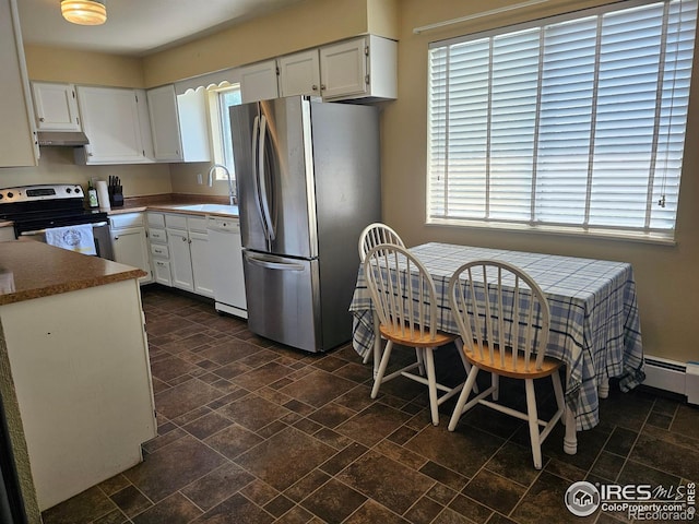 1402 Fillmore St, Sterling, CO 80751 - kitchen with appliances with stainless steel finishes, white cabinets, stone tile flooring, and under cabinet range hood