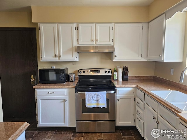 1402 Fillmore St, Sterling, CO 80751 - kitchen with stainless steel electric range oven, black microwave, extractor fan, and white cabinetry