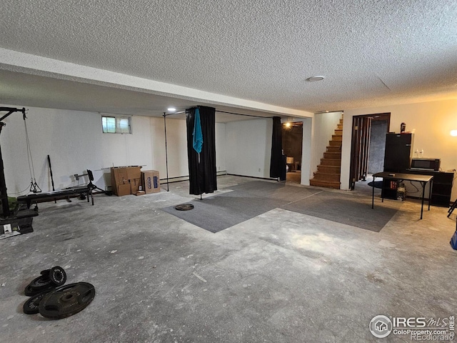 1402 Fillmore St, Sterling, CO 80751 - basement featuring a textured ceiling, stairway, and baseboard heating