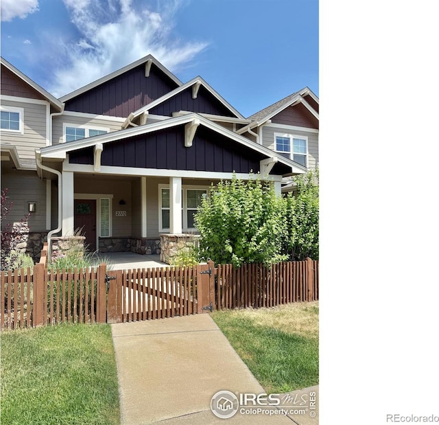 2110 Nancy Gray Ave, Fort Collins, CO 80525 - craftsman house with covered porch, a fenced front yard, board and batten siding, a gate, and stone siding