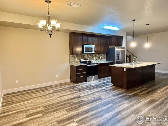 2110 Nancy Gray Ave, Fort Collins, CO 80525 - kitchen with appliances with stainless steel finishes, tasteful backsplash, dark wood-type flooring, dark brown cabinets, and a chandelier