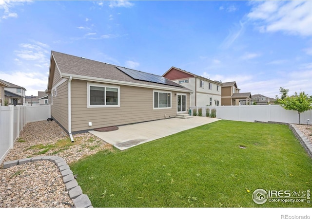 619 Rosedale St, Severance, CO 80550 - rear view of house with solar panels, a patio area, a fenced backyard, and roof with shingles
