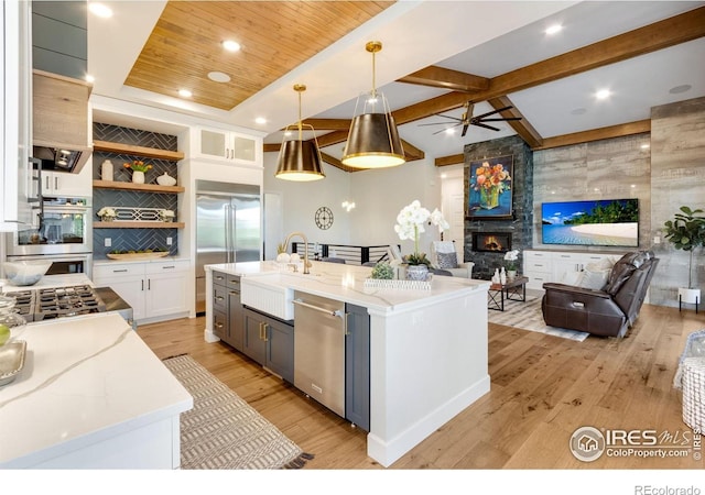 4198 Prestwich Ct, Timnath, CO 80547 - kitchen featuring appliances with stainless steel finishes, open floor plan, white cabinetry, open shelves, and light wood-style flooring