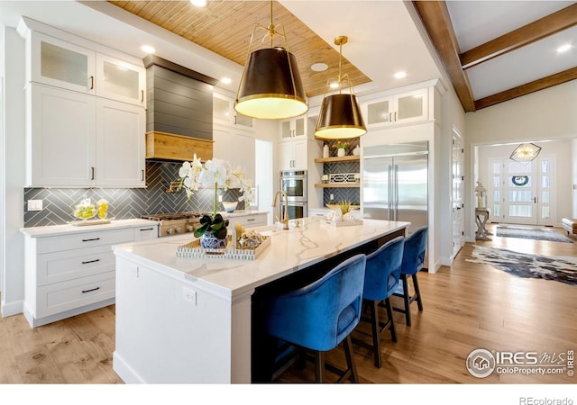4198 Prestwich Ct, Timnath, CO 80547 - kitchen featuring stainless steel appliances, decorative backsplash, light wood-type flooring, a center island with sink, and recessed lighting