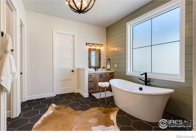 4198 Prestwich Ct, Timnath, CO 80547 - full bath featuring a freestanding tub, vanity, tile patterned floors, and wood walls