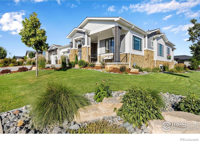 4198 Prestwich Ct, Timnath, CO 80547 - view of front of home with stone siding, a front yard, and covered porch