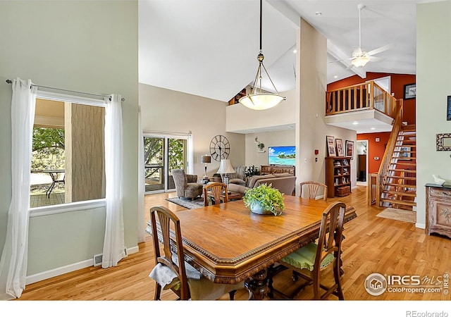 1470 71st Ave, Greeley, CO 80634 - dining area with high vaulted ceiling, light wood-style floors, stairway, and ceiling fan