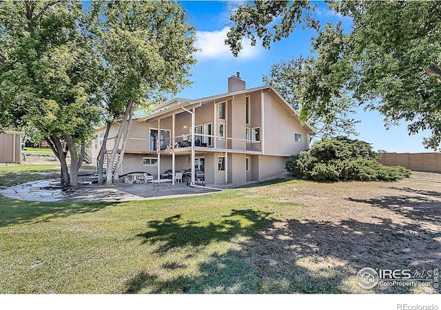 1470 71st Ave, Greeley, CO 80634 - back of property with a patio area, a chimney, and a balcony