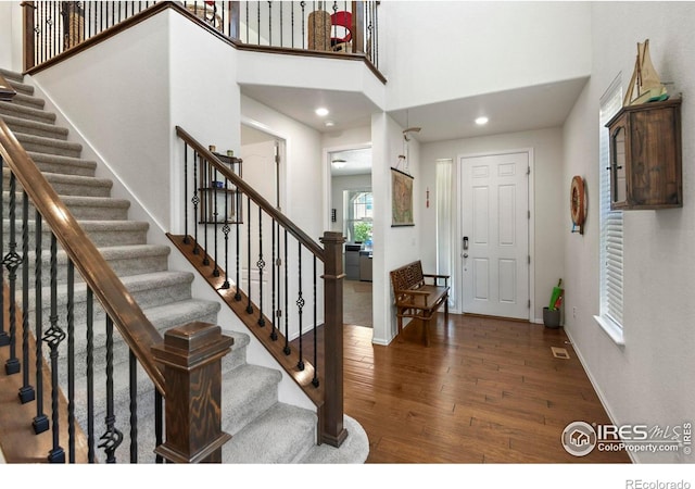 833 Carbonate Ln, Erie, CO 80516 - entrance foyer featuring wood finished floors, stairs, a towering ceiling, and recessed lighting