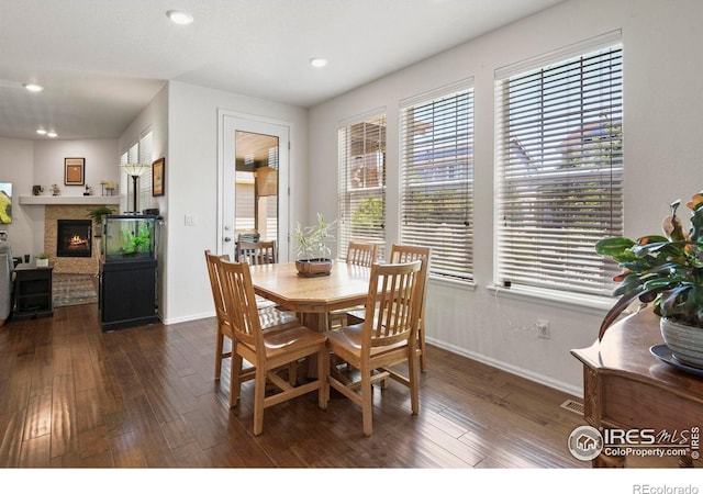833 Carbonate Ln, Erie, CO 80516 - dining room with healthy amount of natural light, dark wood finished floors, a glass covered fireplace, and recessed lighting