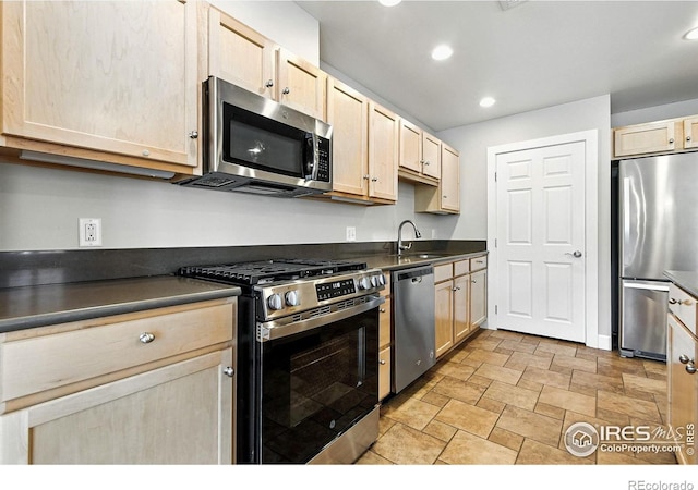 1631 N Emerson St Unit 207, Denver, CO 80218 - kitchen featuring appliances with stainless steel finishes, light brown cabinetry, dark countertops, stone finish flooring, and recessed lighting