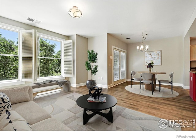 1631 N Emerson St Unit 207, Denver, CO 80218 - living room featuring wood finished floors and a chandelier