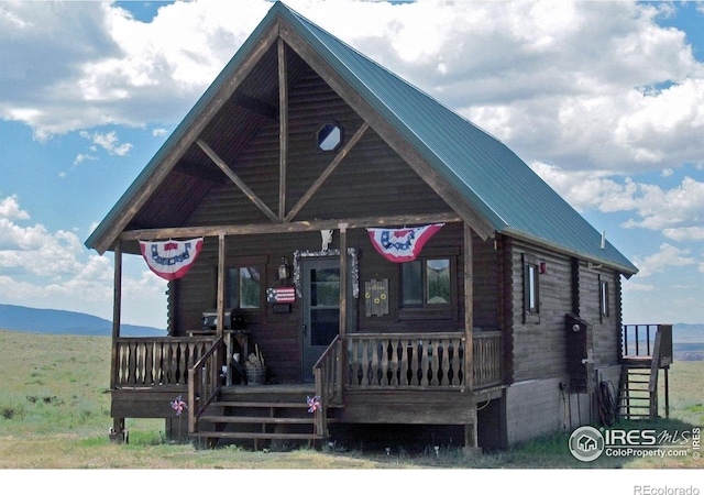 2780 Camel Rock Rd, Red Feather Lakes, CO 80545 - log cabin with a metal roof, a porch, and log siding