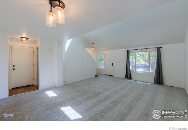 6126 Shamrock Cir, Frederick, CO 80530 - unfurnished living room featuring carpet floors and vaulted ceiling