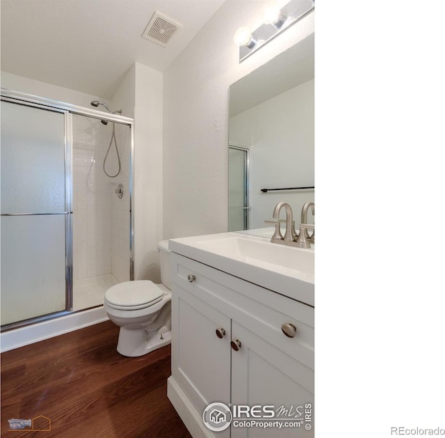6126 Shamrock Cir, Frederick, CO 80530 - full bathroom featuring wood finished floors, vanity, and an enclosed shower