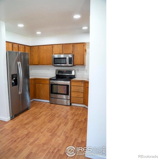 4616 Homestead Ct, Greeley, CO 80634 - kitchen with stainless steel appliances, brown cabinets, light wood-type flooring, light countertops, and recessed lighting