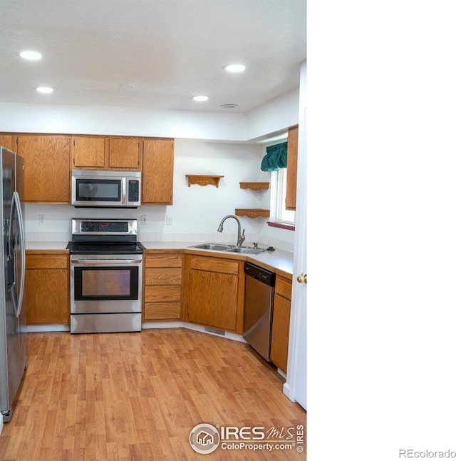 4616 Homestead Ct, Greeley, CO 80634 - kitchen with appliances with stainless steel finishes, brown cabinets, light countertops, light wood-style flooring, and recessed lighting
