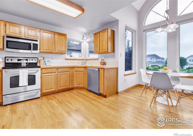 147 Keystone Trl, Broomfield, CO 80020 - kitchen with appliances with stainless steel finishes, light wood-style floors, light countertops, and pendant lighting