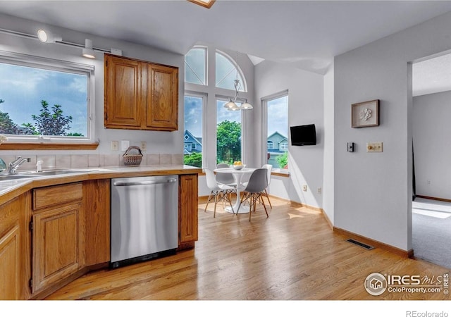 147 Keystone Trl, Broomfield, CO 80020 - kitchen with stainless steel dishwasher, light wood-type flooring, light countertops, and brown cabinetry