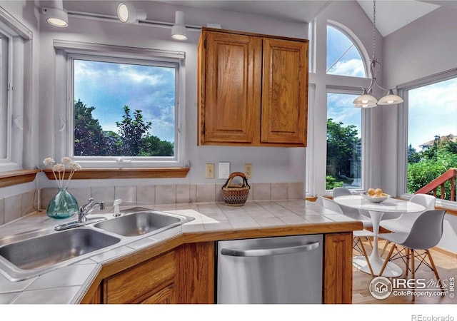 147 Keystone Trl, Broomfield, CO 80020 - kitchen featuring dishwasher, brown cabinets, tile counters, and lofted ceiling