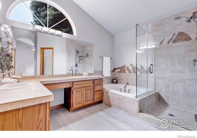 147 Keystone Trl, Broomfield, CO 80020 - full bath with a shower stall, a garden tub, vanity, high vaulted ceiling, and tile patterned flooring