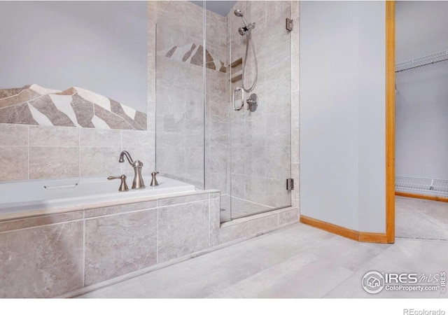 147 Keystone Trl, Broomfield, CO 80020 - bathroom featuring a stall shower, a garden tub, tile patterned flooring, and a spacious closet