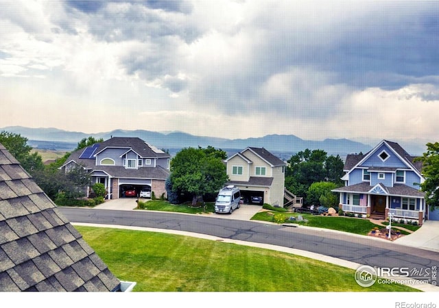 147 Keystone Trl, Broomfield, CO 80020 - view of grassy yard featuring concrete driveway, an attached garage, and a mountain view