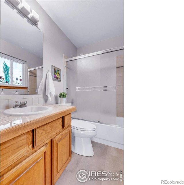 147 Keystone Trl, Broomfield, CO 80020 - full bathroom featuring tile patterned floors, vanity, and bath / shower combo with glass door